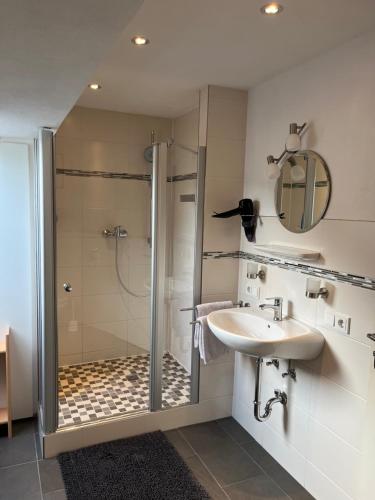 a bathroom with a glass shower and a sink at Mosel Ferienwohnung in Ürzig