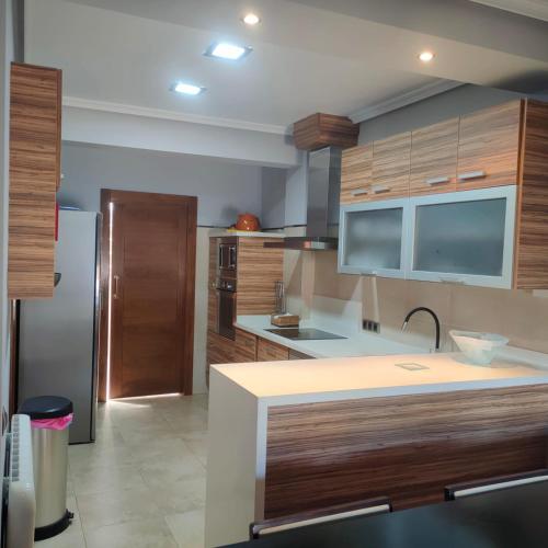 a kitchen with wooden cabinets and a stainless steel refrigerator at vivienda rural AZALEA in Cortijos Nuevos