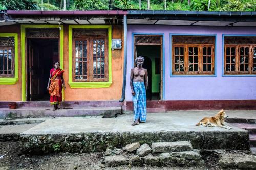 a man standing in front of a building with a dog at Madulkelle Tea and Eco Lodge in Kandy