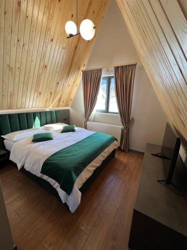 a bedroom with a large bed in a attic at CABANA 7 CRESTE in Borşa