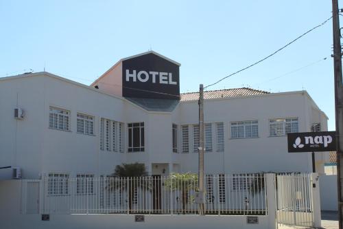 een wit gebouw met een hotelbord erop bij Nap Hotel in Ponta Grossa