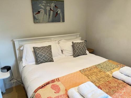 een slaapkamer met een groot bed met witte lakens en kussens bij The Figgy by Bloom Stays in Ashford