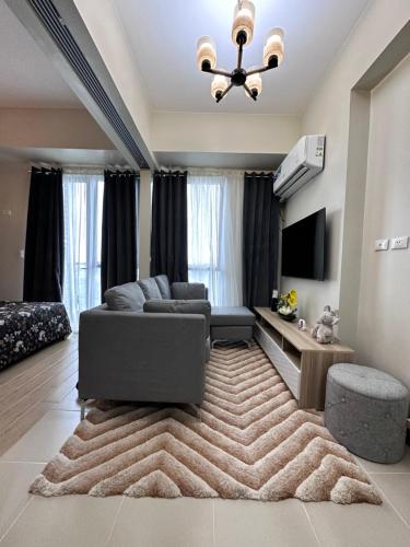 un soggiorno con divano e tappeto di THE PALLADIUM- Serene a Città di Iloilo