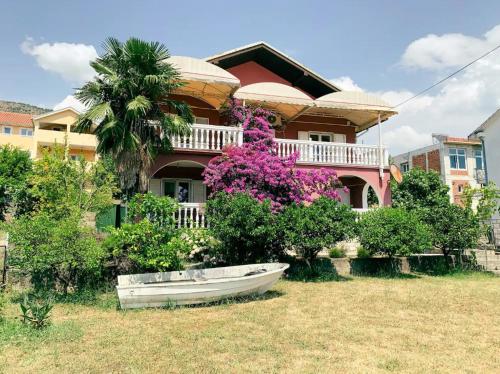 ein Haus mit einem Boot davor in der Unterkunft Peaceful, Cosy Tivat Guesthouse in Tivat