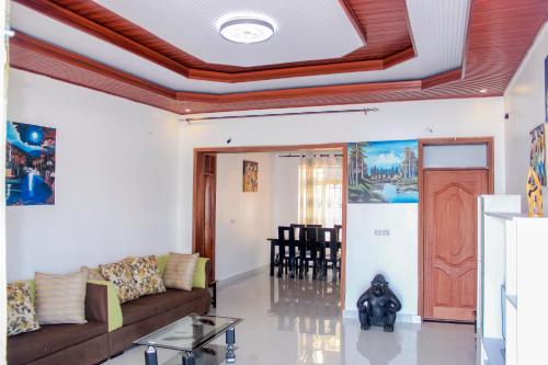 een woonkamer met een bank en een tafel bij Green Safaris Apartment in Rubavu