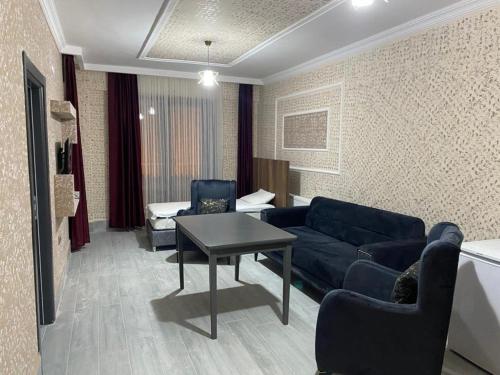 a living room with a couch and chairs and a table at EGE SUİT OTEL in Amasra