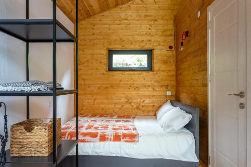 a bedroom with a bed in a room with wooden walls at Gergeti Trio in Kazbegi