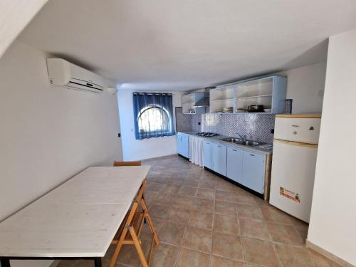 una grande cucina con tavolo e piano di lavoro di Il Paradiso nascosto a Pantelleria