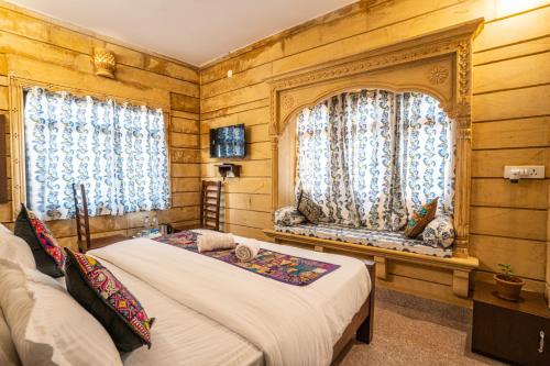 sypialnia z łóżkiem i 2 oknami w obiekcie Hotel Relax Inn Jaisalmer w mieście Jaisalmer