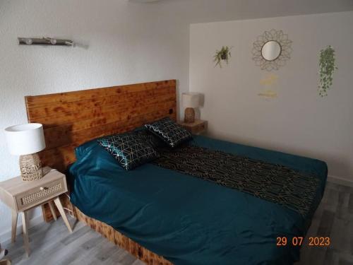 une chambre avec un lit avec une couette bleue dans l'établissement Baby Home cosy à 1km de la mer, à Saint-Cyprien