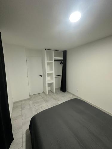 ein Schlafzimmer mit einem schwarzen Bett und einem Schrank in der Unterkunft Appartement Bourg saint andeol in Bourg-Saint-Andéol