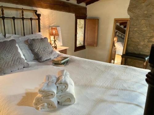 een slaapkamer met een bed met handdoeken erop bij La Grulla Gris in Perales del Puerto
