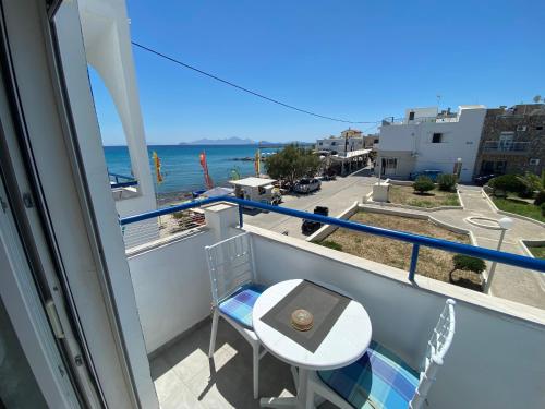 a balcony with a table and a chair and the ocean at Annoula Studios and Apartments in Kardamaina