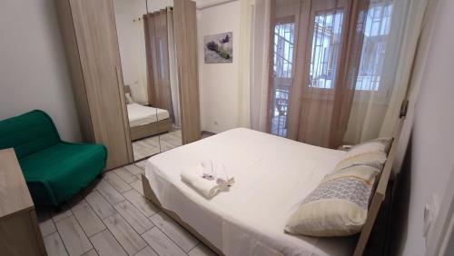 una camera con un letto bianco e una sedia verde di My Little House a Roma