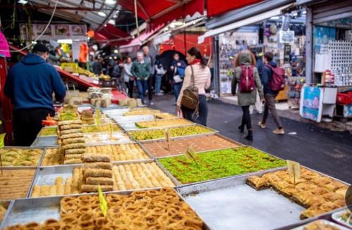 a group of people walking around a market with food at צימר פרטי בבוגרשוב VIp אופציה לחניה in Tel Aviv