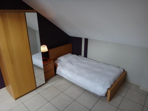 a small bedroom with a bed and a mirror at Holiday home Gîte rural Côté Fagnes in Jalhay