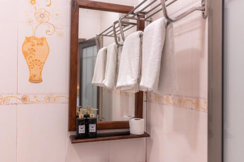 a bathroom with a mirror and towels on a rack at Captal Island Villa in Mathiveri