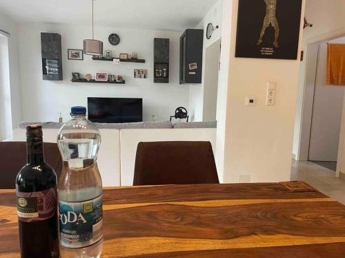 una bottiglia di vino seduta sopra un tavolo di legno di Moderne Wohnung mit Stil a Grossgerungs