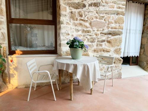 a table and chairs with a vase of flowers on it at La Grulla Gris in Perales del Puerto