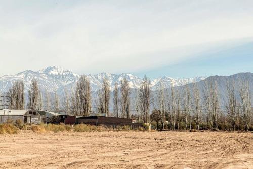 a house in a field with mountains in the background at Lujoso dpto Moreno Park en Lujan in Ciudad Lujan de Cuyo
