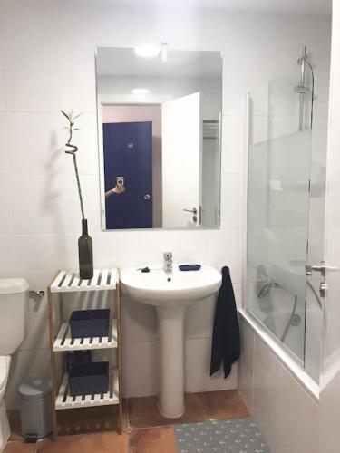 a white bathroom with a sink and a mirror at Studio De Ziutek in La Pared