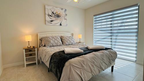 The Salt Life Get Away - Cape Coral, Florida في كيب كورال: غرفة نوم بسرير ومصباح ونافذة