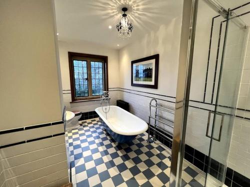 La salle de bains est pourvue d'une baignoire, d'une douche et d'un lavabo. dans l'établissement 3 Bed Apartment Sleeps 6 Country House in Warwick, à Warwick