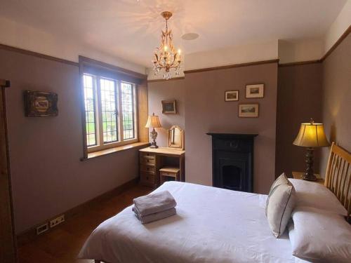 a bedroom with a white bed and a chandelier at 3 Bed Apartment Sleeps 6 Country House in Warwick in Warwick