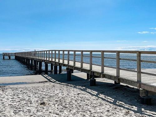 a wooden pier on the beach next to the water at 4 person holiday home in Beddingestrand-By Traum in Beddinge Strand