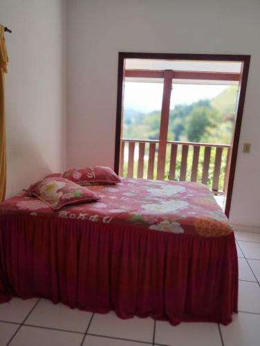 uma cama num quarto com uma janela em Refugio Das Pedras em Paraty