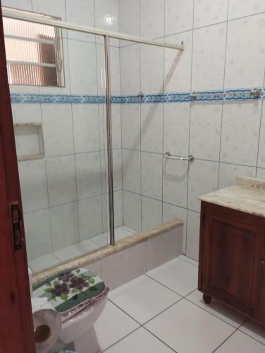 uma casa de banho com um chuveiro, um WC e um lavatório. em Refugio Das Pedras em Paraty