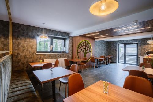 restauracja ze stołami i krzesłami oraz bar w obiekcie APARTHOTEL KLEOSIN w mieście Kleosin