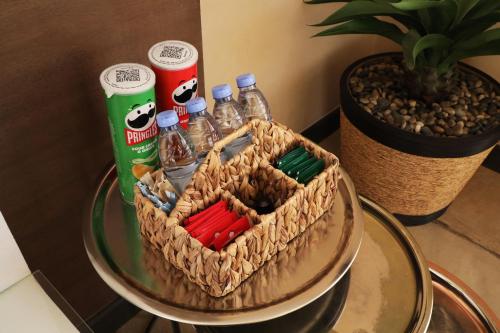 a glass table with a basket with bottles of soda at The Cliff Resort in Riyadh
