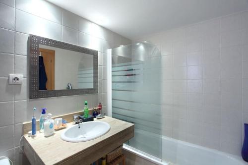 een badkamer met een wastafel, een spiegel en een bad bij RESIDENTIAL FLAT Lloret de Mar (Nex in Lloret de Mar