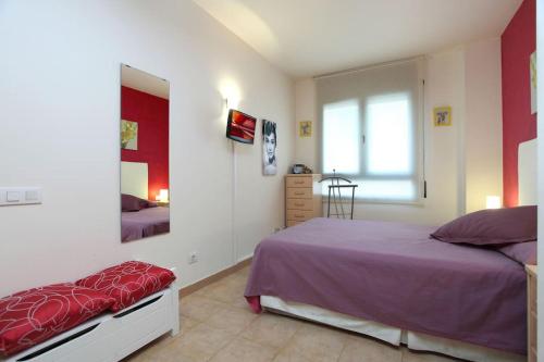 een slaapkamer met een paars bed en een spiegel bij RESIDENTIAL FLAT Lloret de Mar (Nex in Lloret de Mar