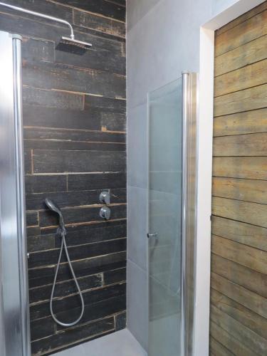 y baño con ducha y pared de madera. en The Ultimate Stay, en Ginton