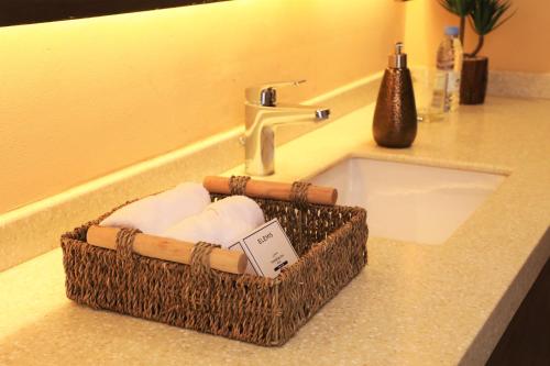 een mand met handdoeken naast een wastafel bij The Cliff Resort in Riyad