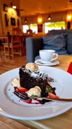 a piece of cake on a white plate on a table at Perełka Bieszczady Domki in Cisna