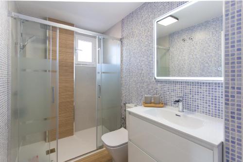 a bathroom with a toilet and a sink and a shower at Aires de Doñana. Piscina y Playa. Parking gratis. in Sanlúcar de Barrameda
