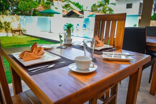 a wooden table with a cup of coffee on it at Saayoo Resort in Negombo