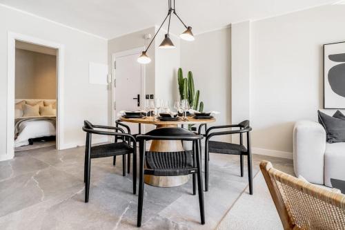 comedor con mesa y sillas negras en Super Stylish Apartment in Fantastic Location, en Marbella