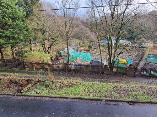 a fence in front of a yard with a house at 4 Bedroom Spacious House Perfect for Family & Business Short Long-Term Stays Easy Access to Manchester, Oldham, Bury in Rochdale