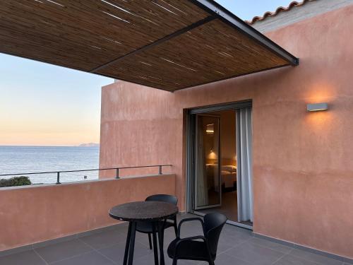 a patio with a table and chairs and the ocean at Pasithea Suites in Monemvasia