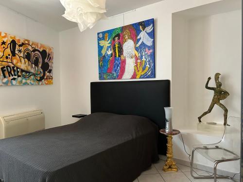 a bedroom with a bed and a statue on the wall at Intérieur d'Artistes in Montélimar
