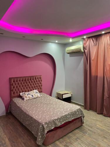 a bedroom with a large bed with a pink ceiling at حدائق الاهرام in ‘Ezbet `Abd el-Ḥamîd