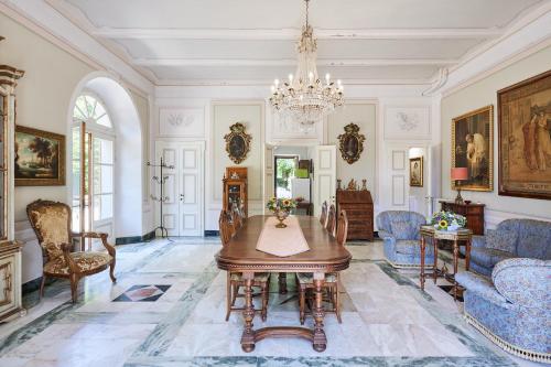 uma sala de jantar com uma mesa e cadeiras e um lustre em Villa Augusto em Cortona