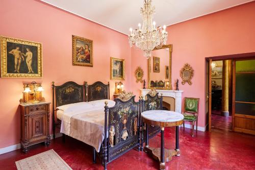 una camera con letto e lampadario a braccio di Villa Augusto a Cortona