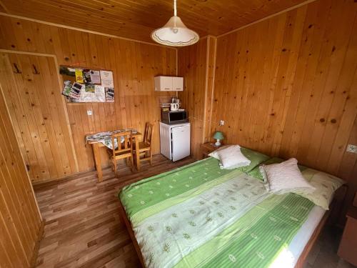 a bedroom with a green bed in a wooden room at Przystanek Wetlina in Wetlina