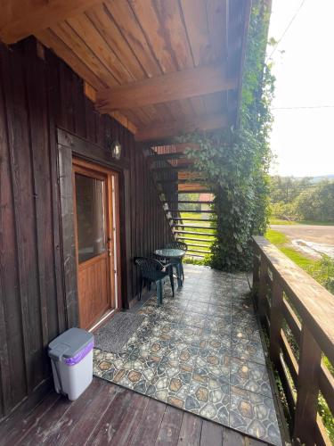 un portico di una casa con tavolo e panchina di Przystanek Wetlina a Wetlina