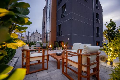 un patio con sillas, una mesa y un edificio en APARTHOTEL KLEOSIN, en Kleosin